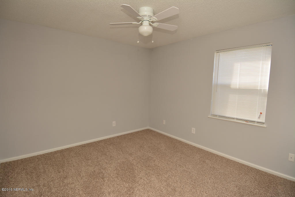 3156 Ricky Drive Jacksonville, FL 32223 - Photo 5 of 9 an empty room with a window and a fan