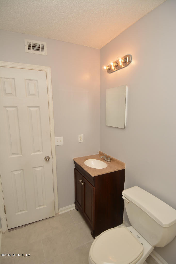 3156 Ricky Drive Jacksonville, FL 32223 - Photo 7 of 9 a bathroom with a toilet a sink and mirror