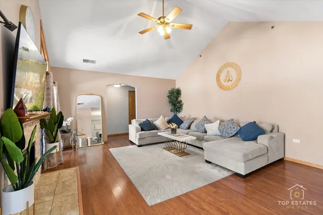 a living room with furniture flowerpot and a chandelier