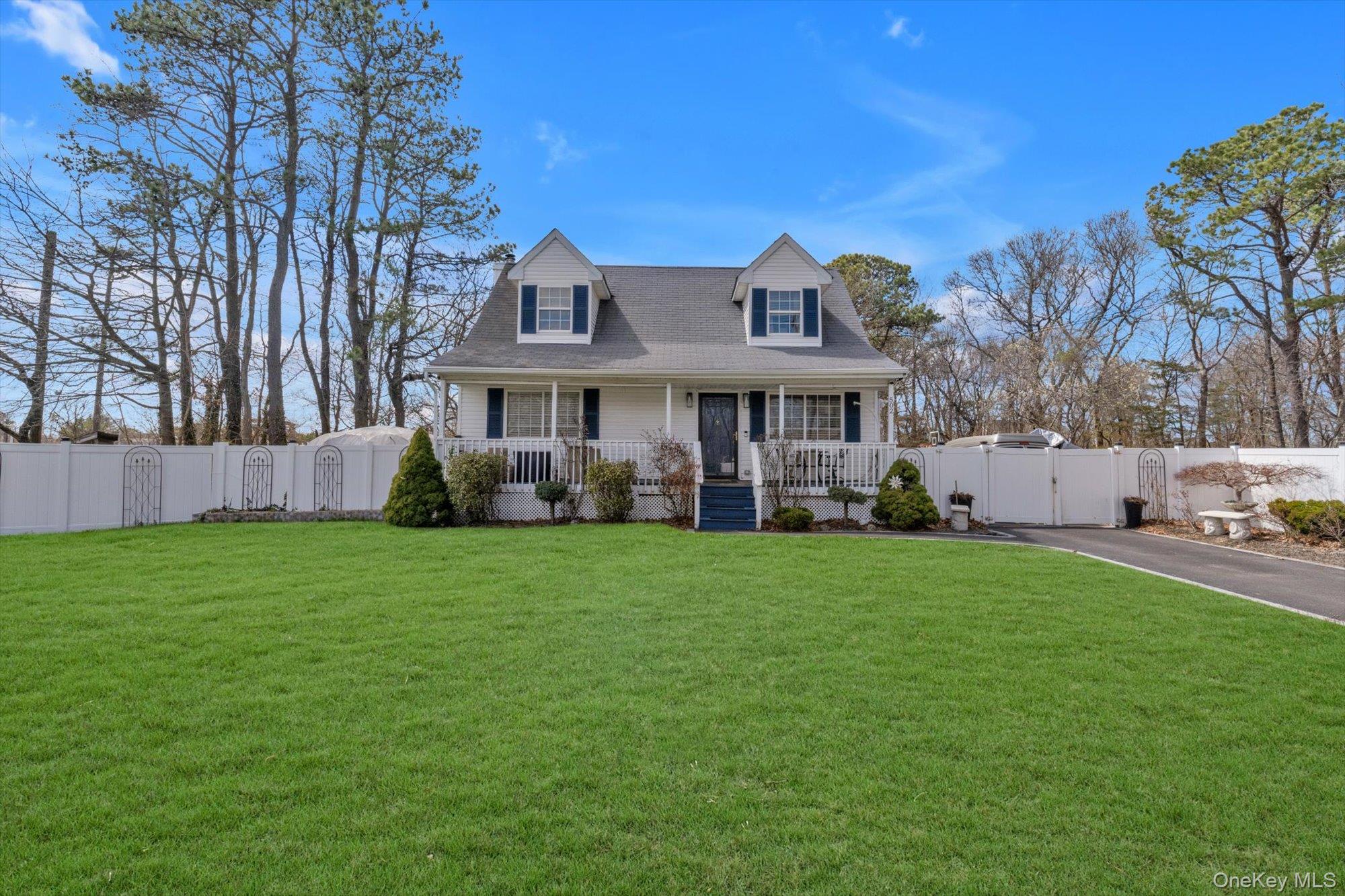 a front view of a house with a garden and trees