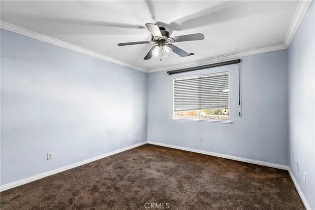 an empty room with a window and a fan
