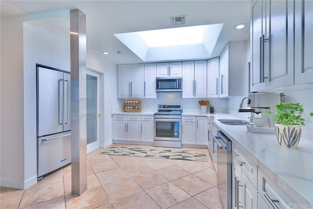 13425 Java Drive Beverly Hills, CA 90210 - Photo 16 of 34 a kitchen with granite countertop a refrigerator a sink a stove a microwave and island