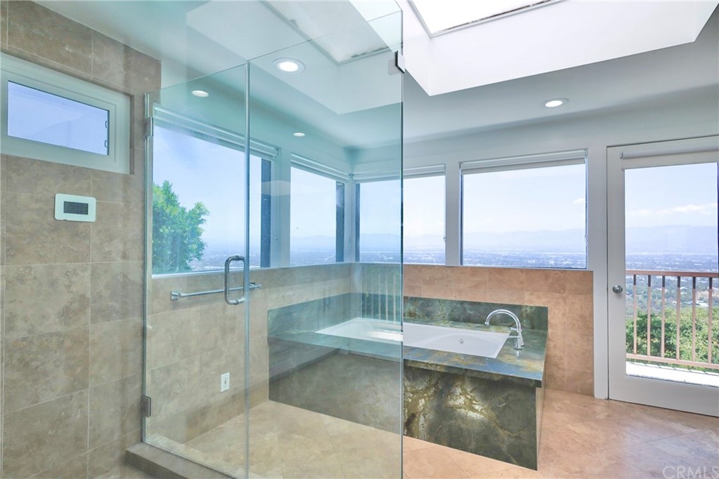 13425 Java Drive Beverly Hills, CA 90210 - Photo 22 of 34 a bathroom with a glass shower door and a bathtub
