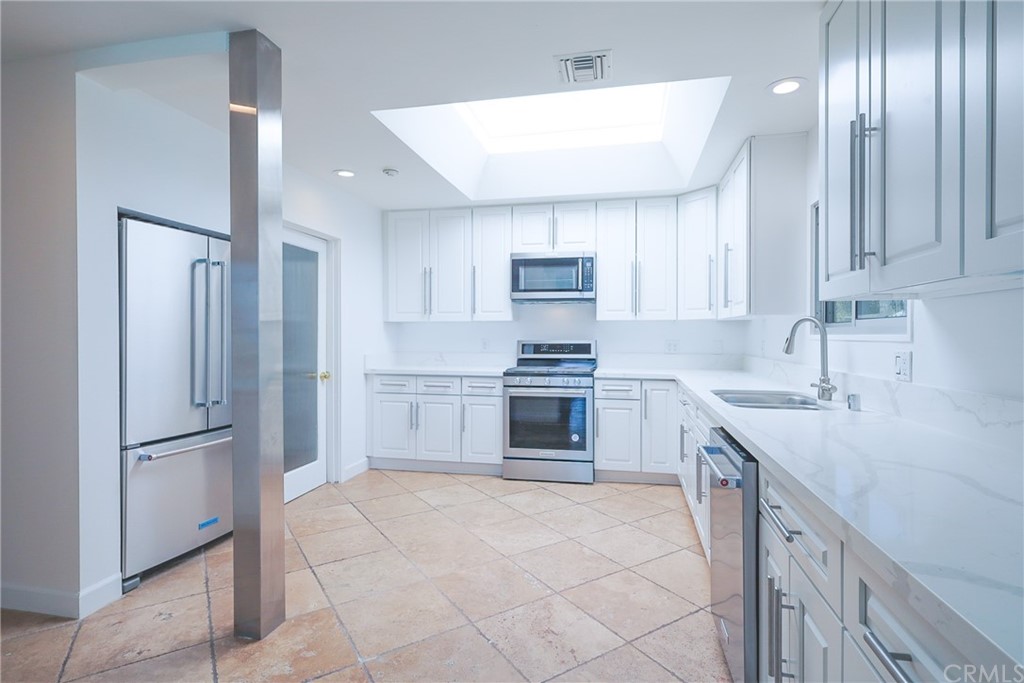 13425 Java Drive Beverly Hills, CA 90210 - Photo 24 of 34 a kitchen with a refrigerator sink and cabinets
