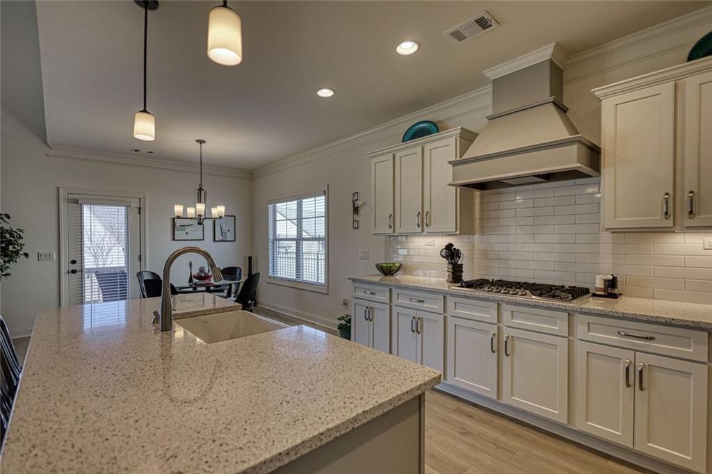 612 Haven Way Monroe, GA 30655 - Photo 11 of 44 a kitchen with granite countertop a sink a stove and cabinets
