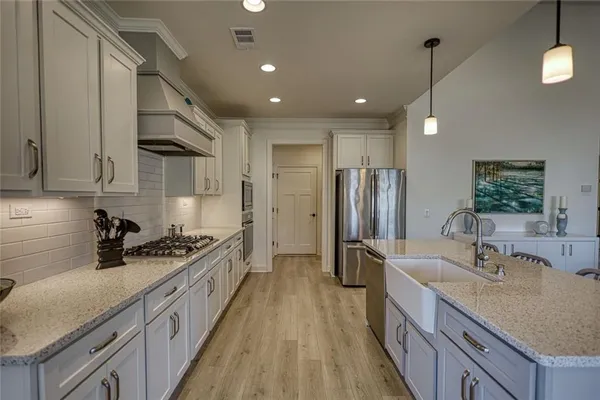 a kitchen with stainless steel appliances a sink stove and refrigerator