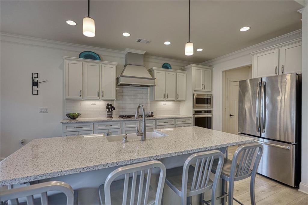612 Haven Way Monroe, GA 30655 - Photo 13 of 44 a kitchen with kitchen island a refrigerator a sink and a stove