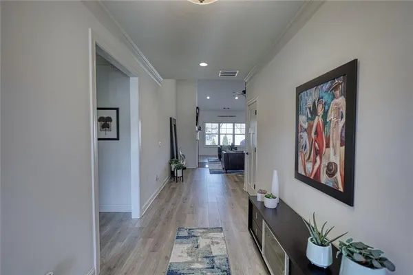 a hallway with wooden floor windows and plants