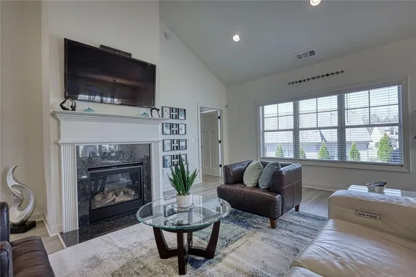 a living room with furniture a flat screen tv and a fireplace