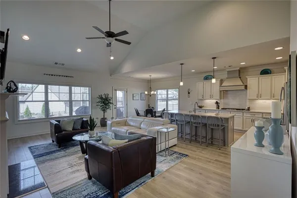 a living room with furniture a large window and kitchen view