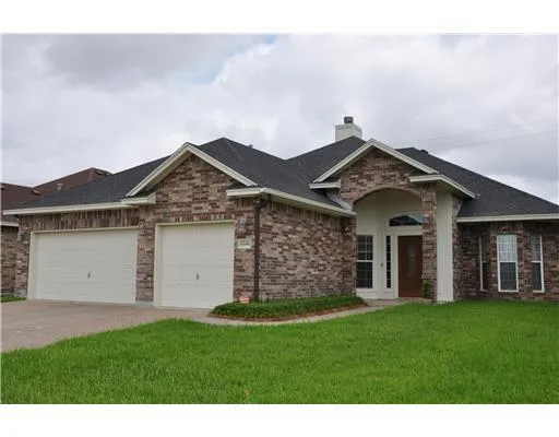 a front view of a house with a garden and yard