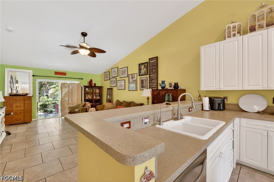 5520 Phillips Street Bokeelia, FL 33922 - Photo 16 of 50 a very nice looking dining room with kitchen island a stove a sink dishwasher and white cabinets with wooden floor