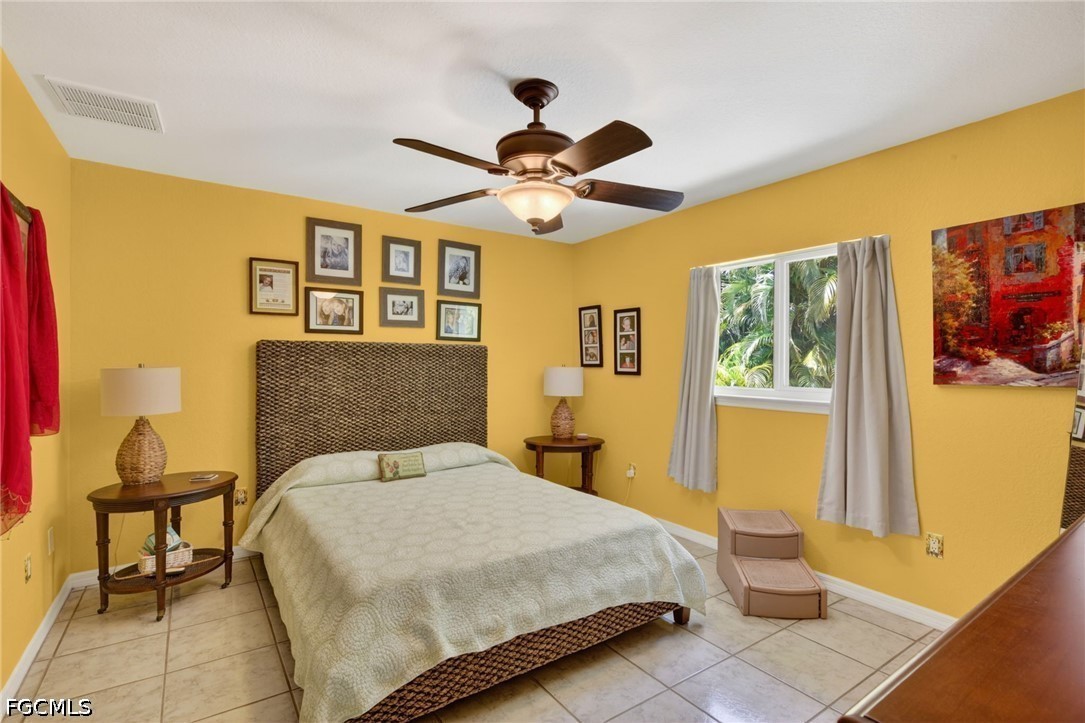 5520 Phillips Street Bokeelia, FL 33922 - Photo 21 of 50 a bedroom with a bed and a chandelier