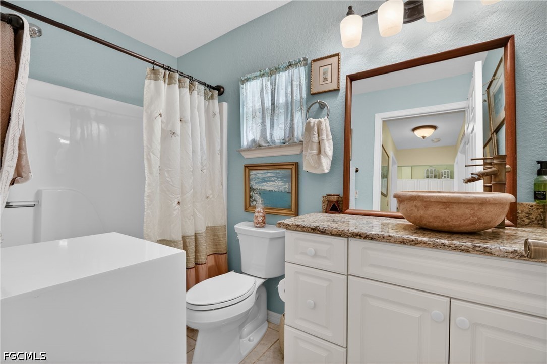 5520 Phillips Street Bokeelia, FL 33922 - Photo 25 of 50 a bathroom with a granite countertop sink mirror vanity and toilet