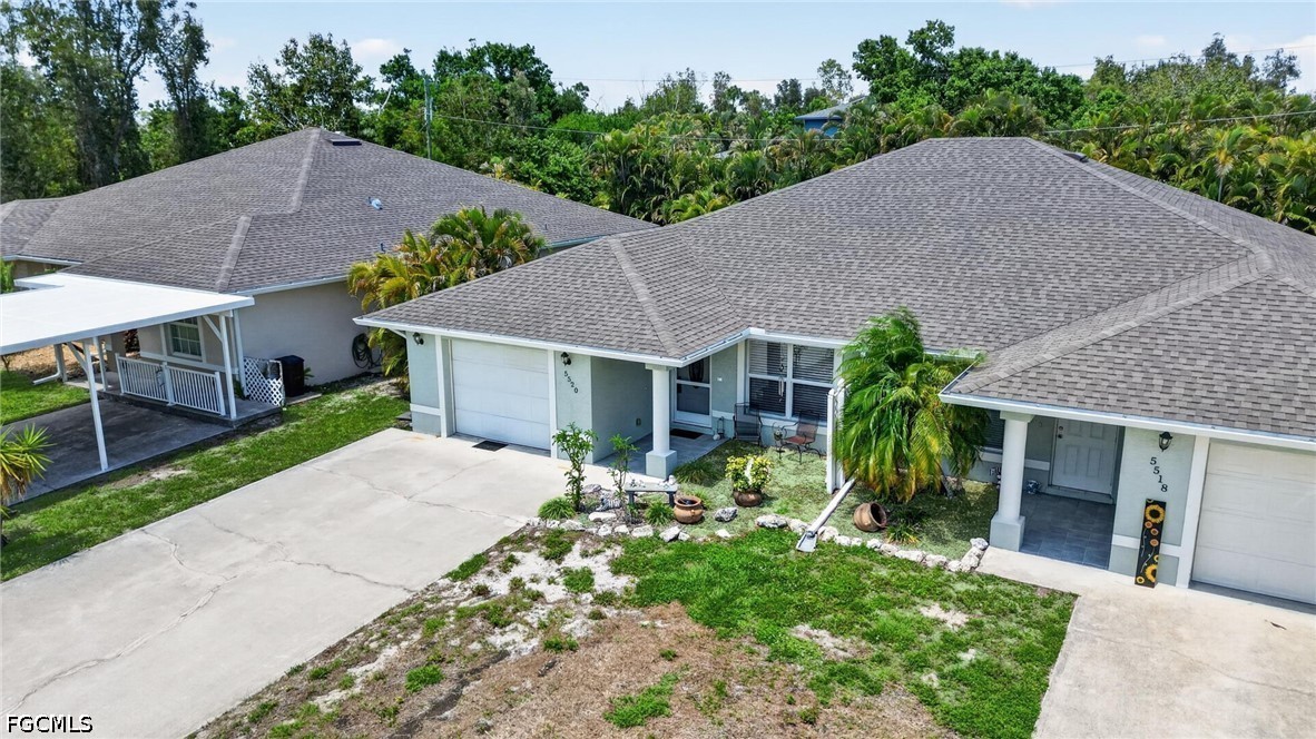 5520 Phillips Street Bokeelia, FL 33922 - Photo 45 of 50 a house with a yard plants and large tree