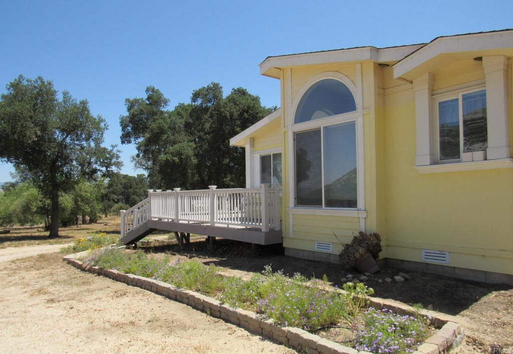 1124 Far Valley Road Campo, CA 91906 - Photo 1 of 21 a view of a small house with yard and trees in the background