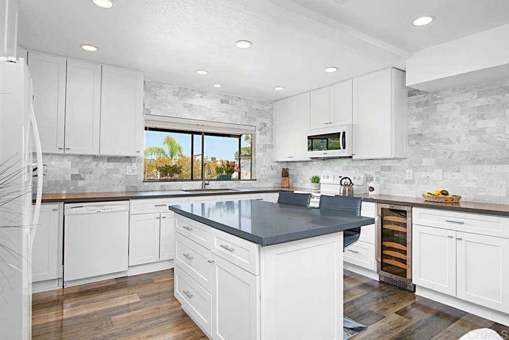2372 Altisma Way, Unit C Carlsbad, CA 92009 - Photo 11 of 30 a kitchen with stainless steel appliances granite countertop a sink stove and cabinets