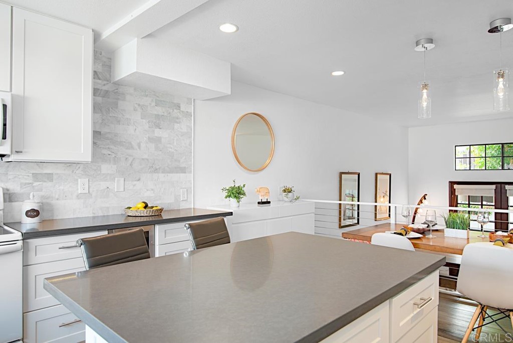 2372 Altisma Way, Unit C Carlsbad, CA 92009 - Photo 12 of 30 a kitchen with a sink a stove and chairs