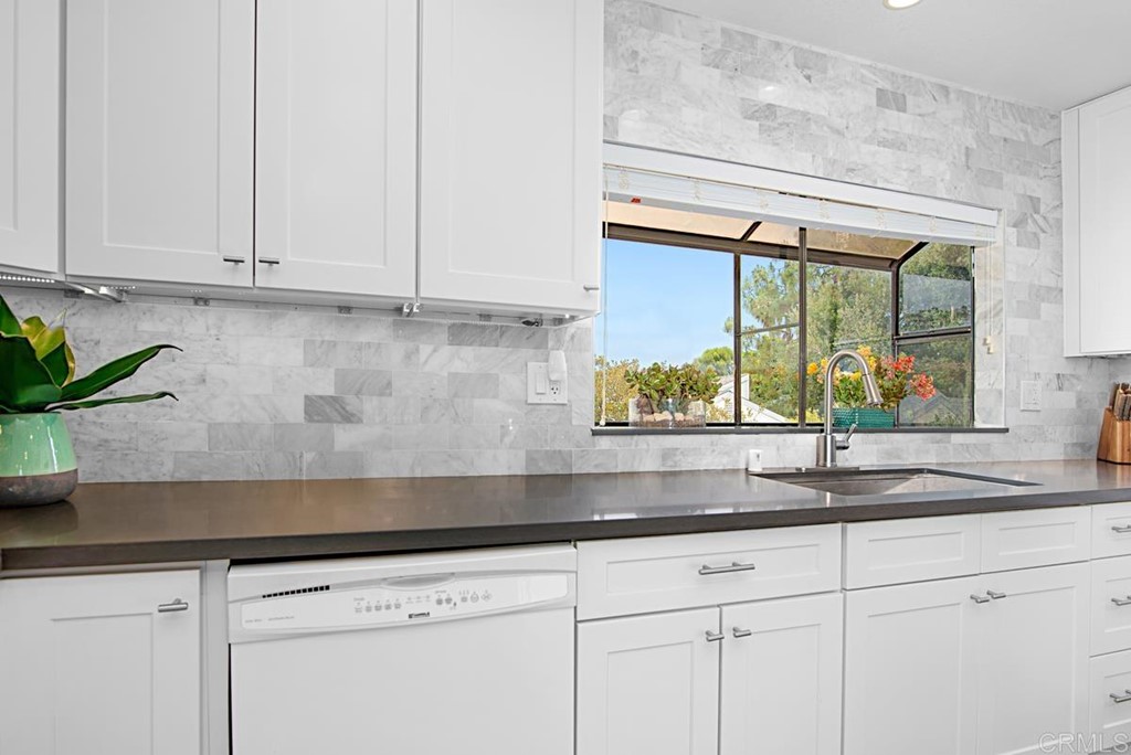 2372 Altisma Way, Unit C Carlsbad, CA 92009 - Photo 15 of 30 a kitchen with stainless steel appliances white cabinets and a granite counter tops