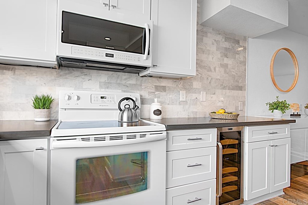 2372 Altisma Way, Unit C Carlsbad, CA 92009 - Photo 16 of 30 a kitchen with stainless steel appliances white cabinets and a stove top oven