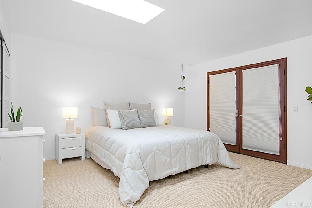 2372 Altisma Way, Unit C Carlsbad, CA 92009 - Photo 18 of 30 a bedroom with a bed lamp and a potted plant