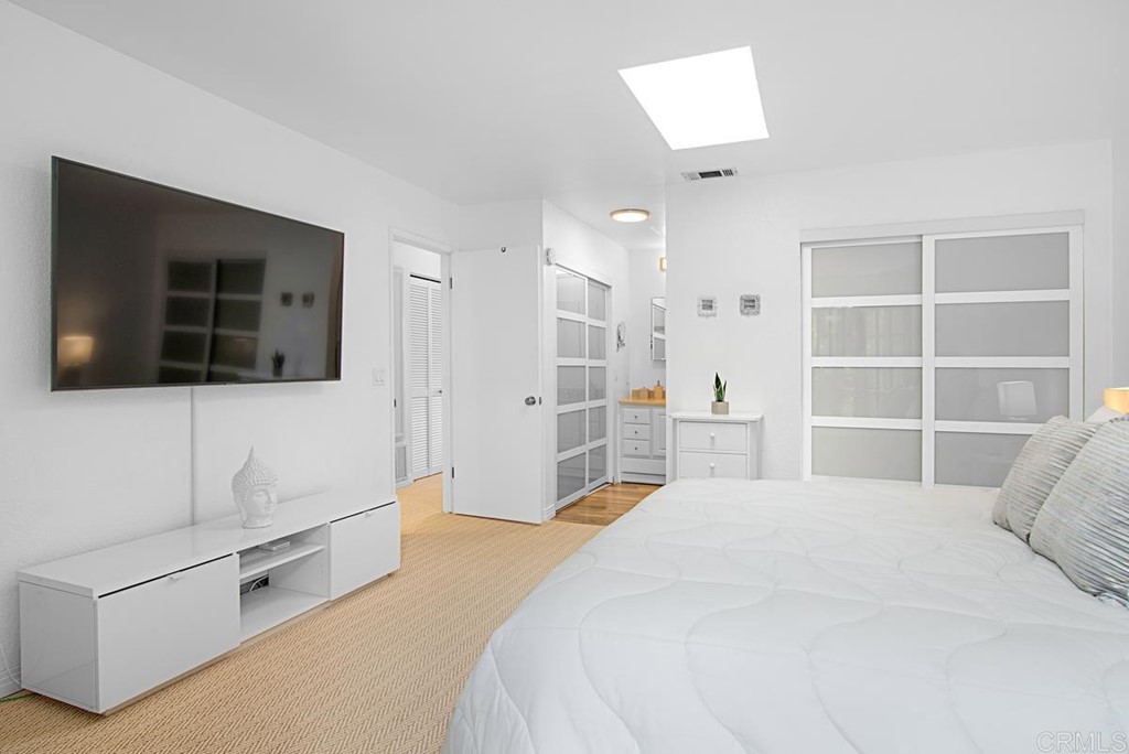 2372 Altisma Way, Unit C Carlsbad, CA 92009 - Photo 21 of 30 a bedroom with a bed and a flat screen tv