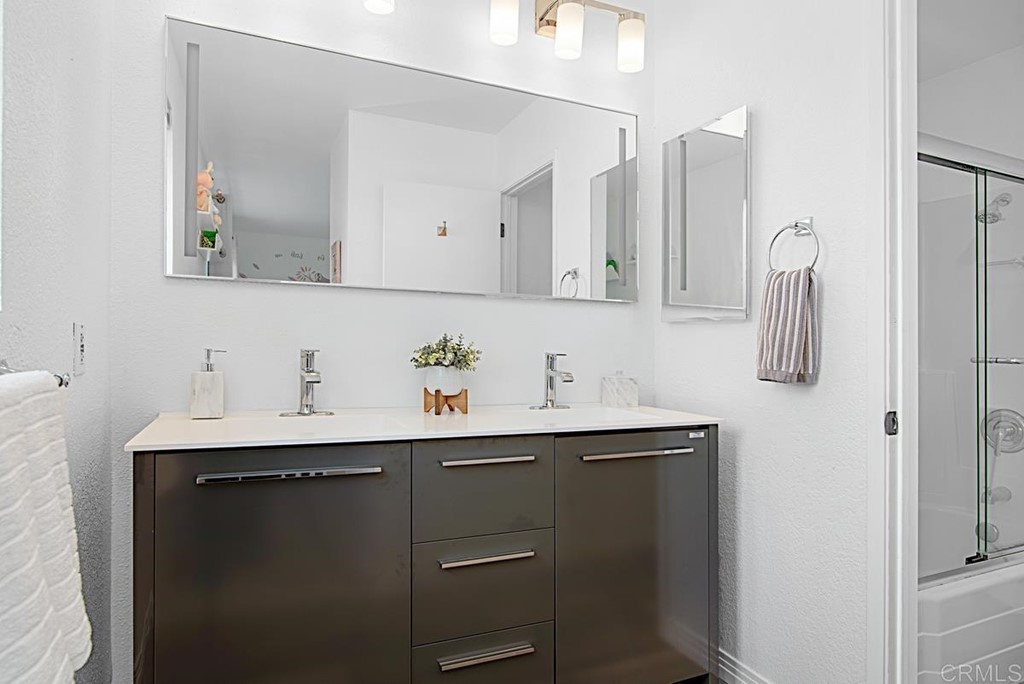 2372 Altisma Way, Unit C Carlsbad, CA 92009 - Photo 27 of 30 a bathroom with a sink and mirror