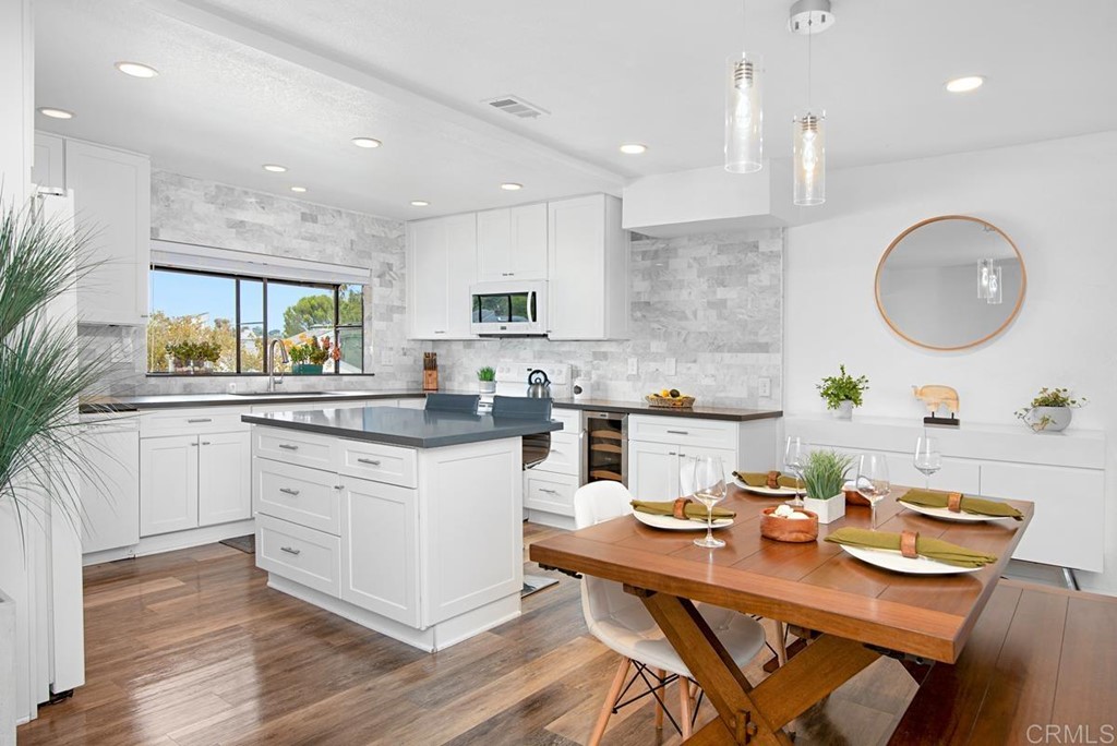 2372 Altisma Way, Unit C Carlsbad, CA 92009 - Photo 10 of 30 a kitchen with white cabinets stove and kitchen island