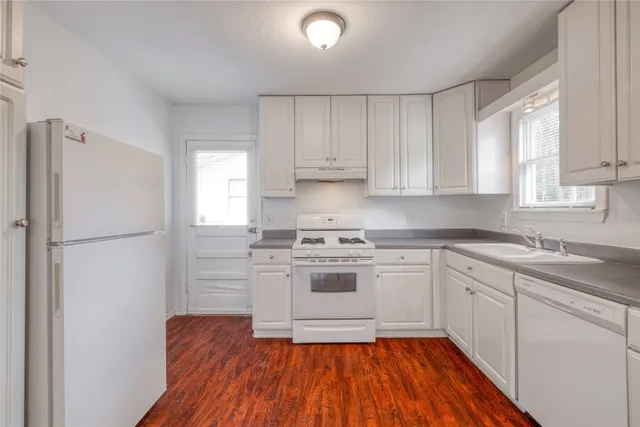 a kitchen with a refrigerator sink and cabinets