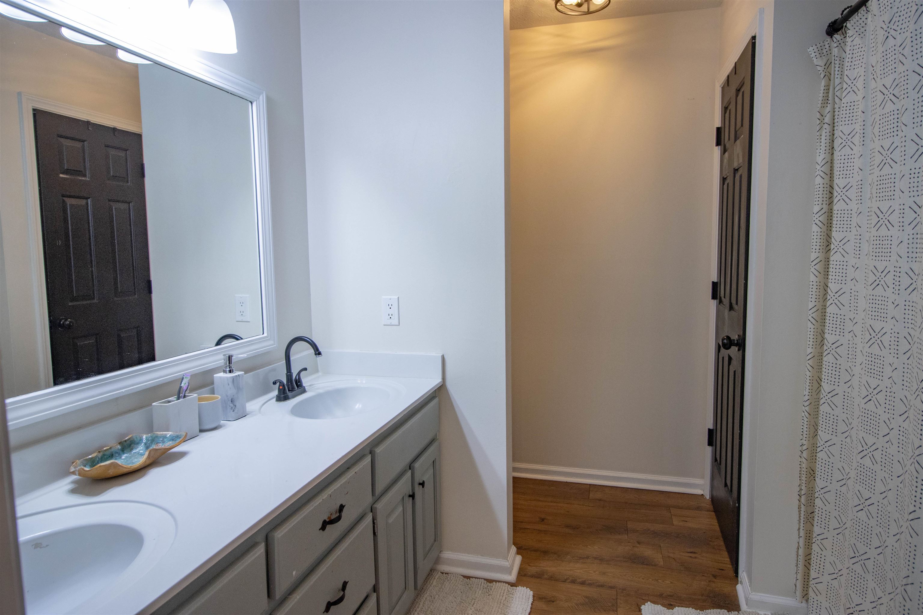 120 Craig Road Ripley, TN 38063 - Photo 16 of 38 Dual vanity with integrated sinks and matte black fixtures, set against a large framed mirror with overhead lighting