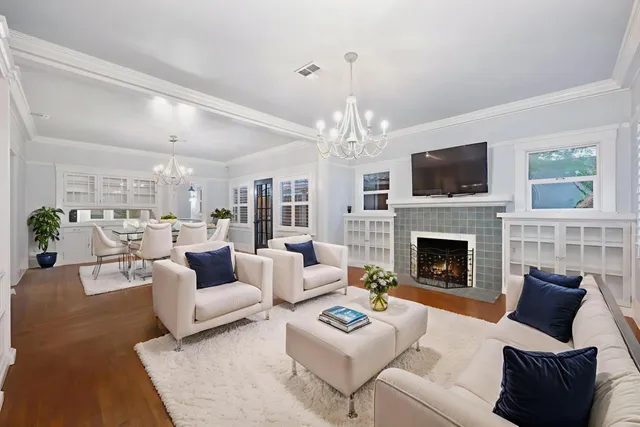 a living room with furniture a chandelier and a fireplace