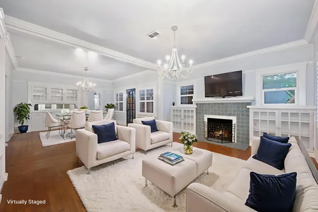 a living room with furniture a chandelier and a fireplace
