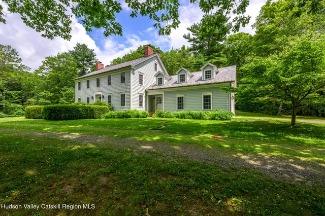 a house with green field in front of it
