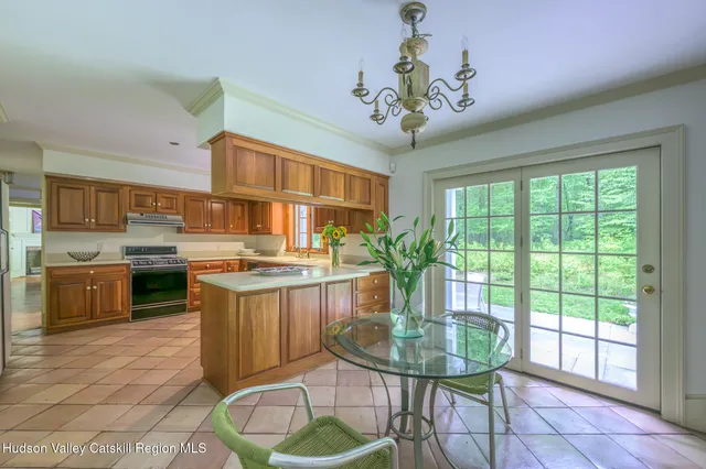 a kitchen with kitchen island a large window cabinets a sink and stainless steel appliances