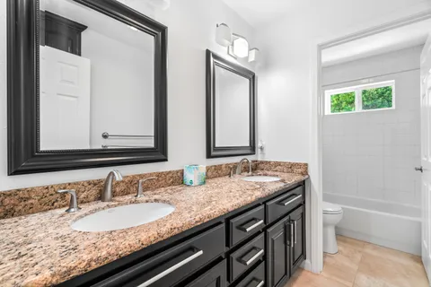 a bathroom with a granite countertop sink and a mirror