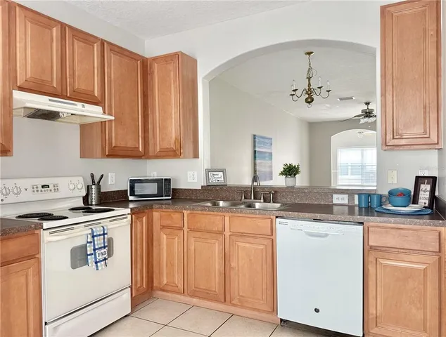 a kitchen with stainless steel appliances granite countertop a sink stove and cabinets