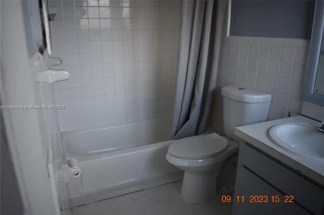 a white toilet sitting next to a bathroom sink and a shower