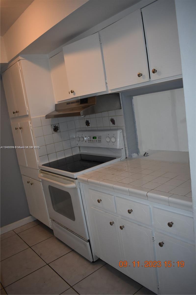 1885 Northeast 121st Street, Unit 23 North Miami, FL 33181 - Photo 4 of 22 a stove top oven sitting inside of a kitchen