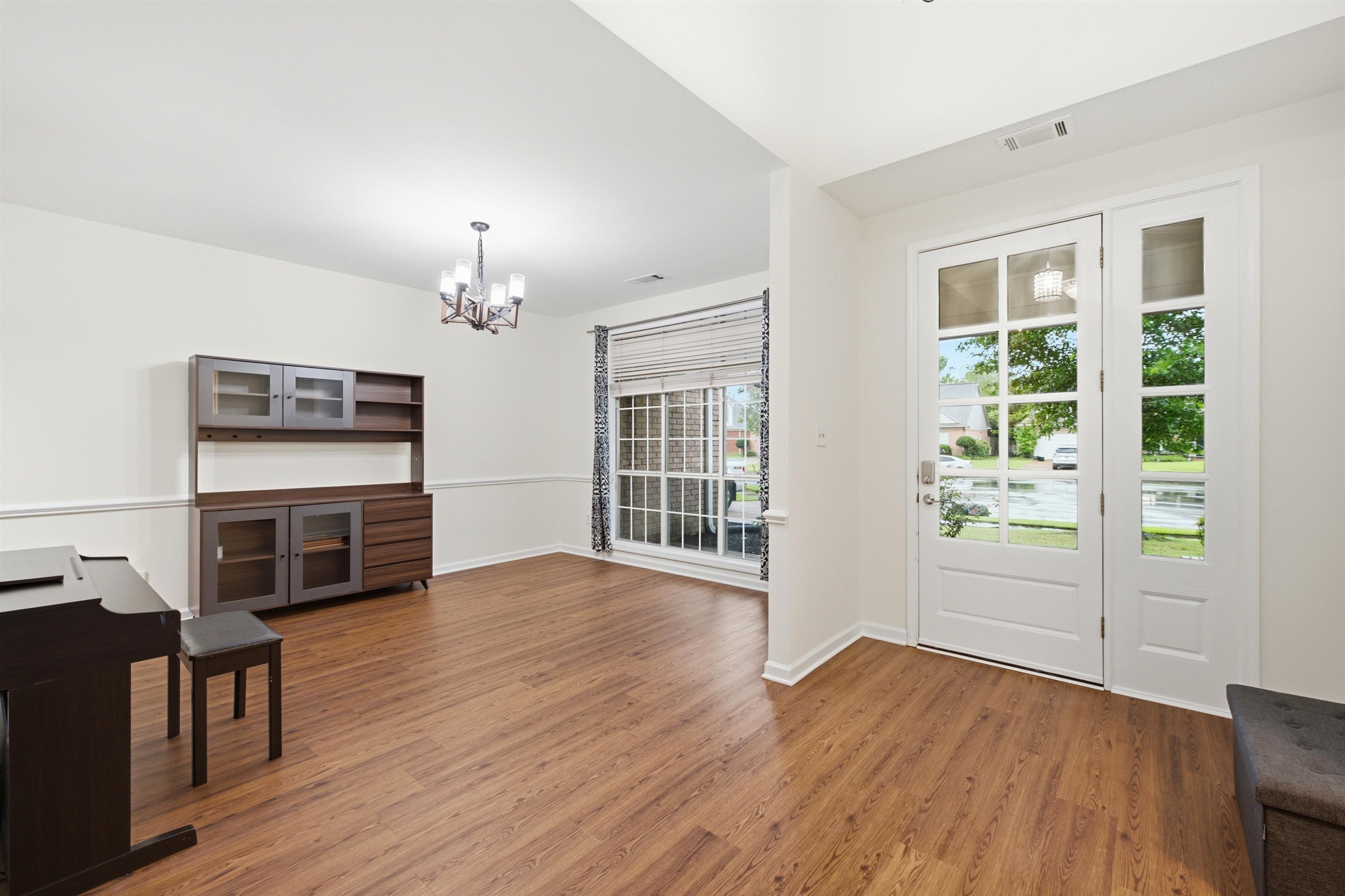 96 Berryfield Cove Collierville, TN 38017 - Photo 5 of 39 Entryway and open room featuring wood-finish flooring, a white paneled door with glass inserts, and a coordinating sidelight
