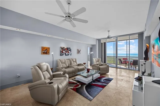 a living room with furniture and floor to ceiling window