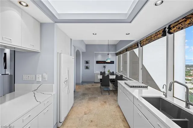 a large white kitchen with stainless steel appliances