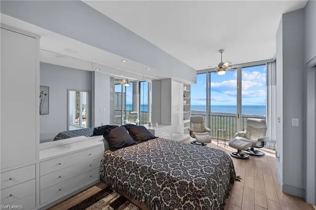 a bedroom with a bed and large windows