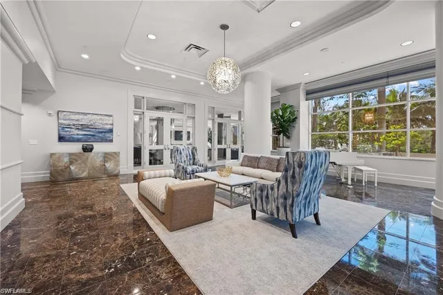a living room with furniture a chandelier and a dining table
