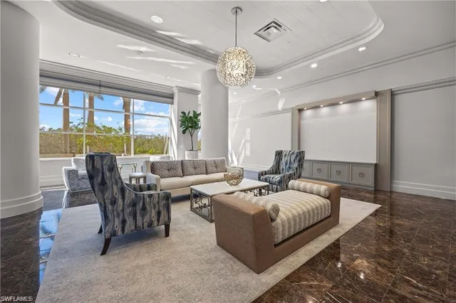 a living room with furniture a chandelier and a large window