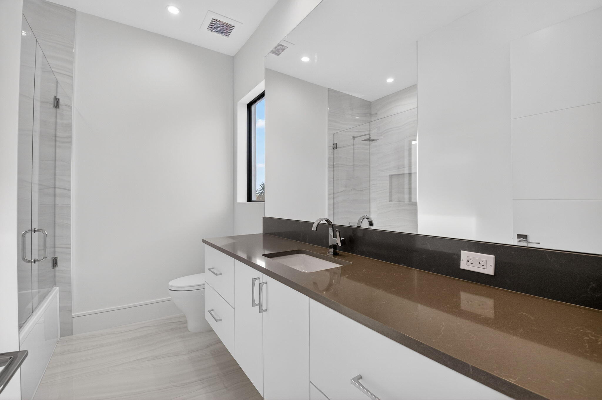 2232 Delray Ridge Lane Delray Beach, FL 33444 - Photo 56 of 68 a spacious bathroom with a granite countertop sink and a mirror