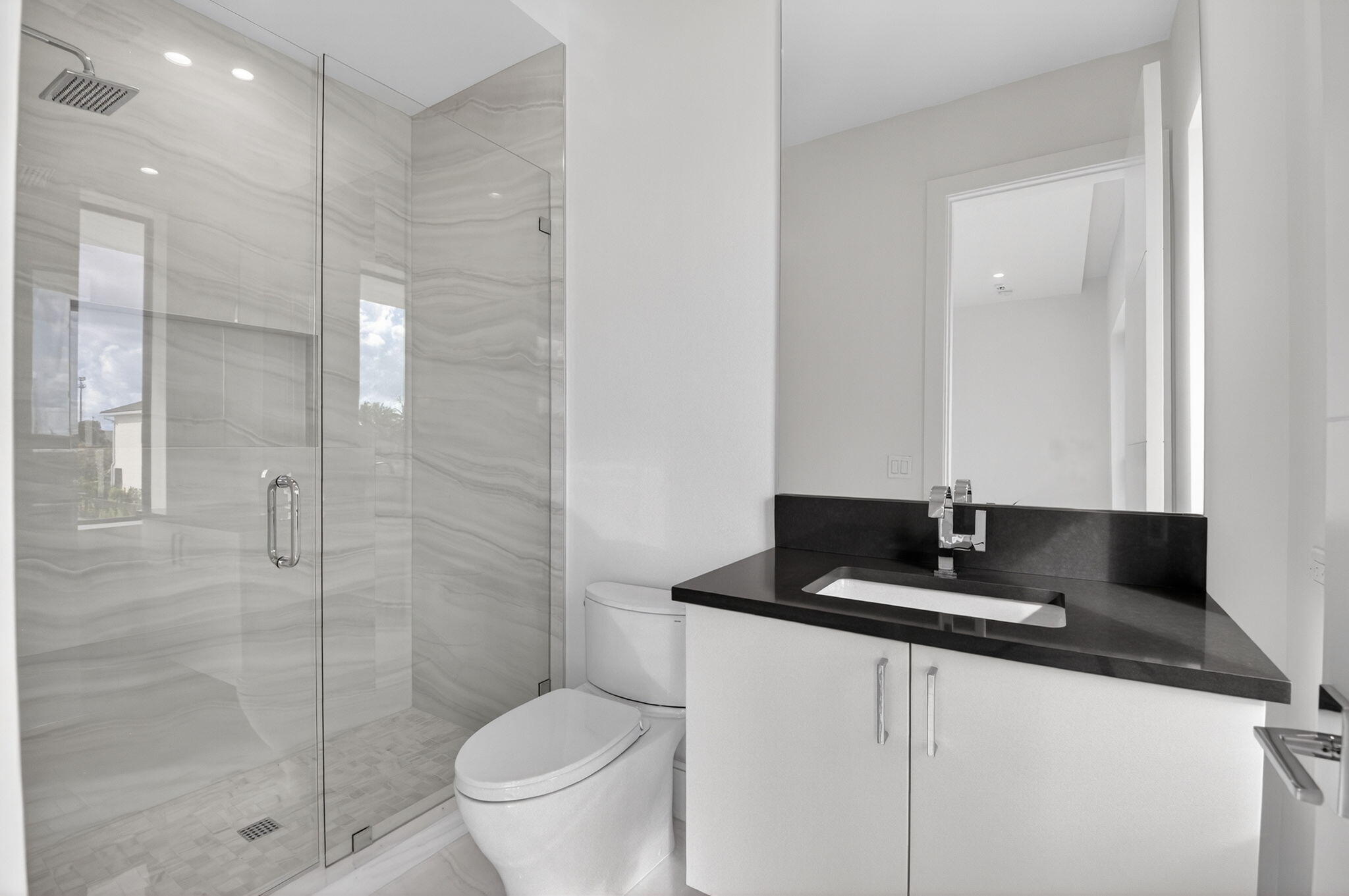 2232 Delray Ridge Lane Delray Beach, FL 33444 - Photo 58 of 68 a bathroom with a granite countertop sink a toilet a mirror and shower