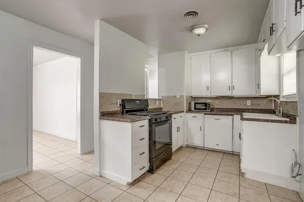 a kitchen with cabinets appliances and a window
