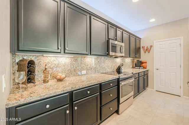 a large kitchen with kitchen island a sink counter space dining table and chairs