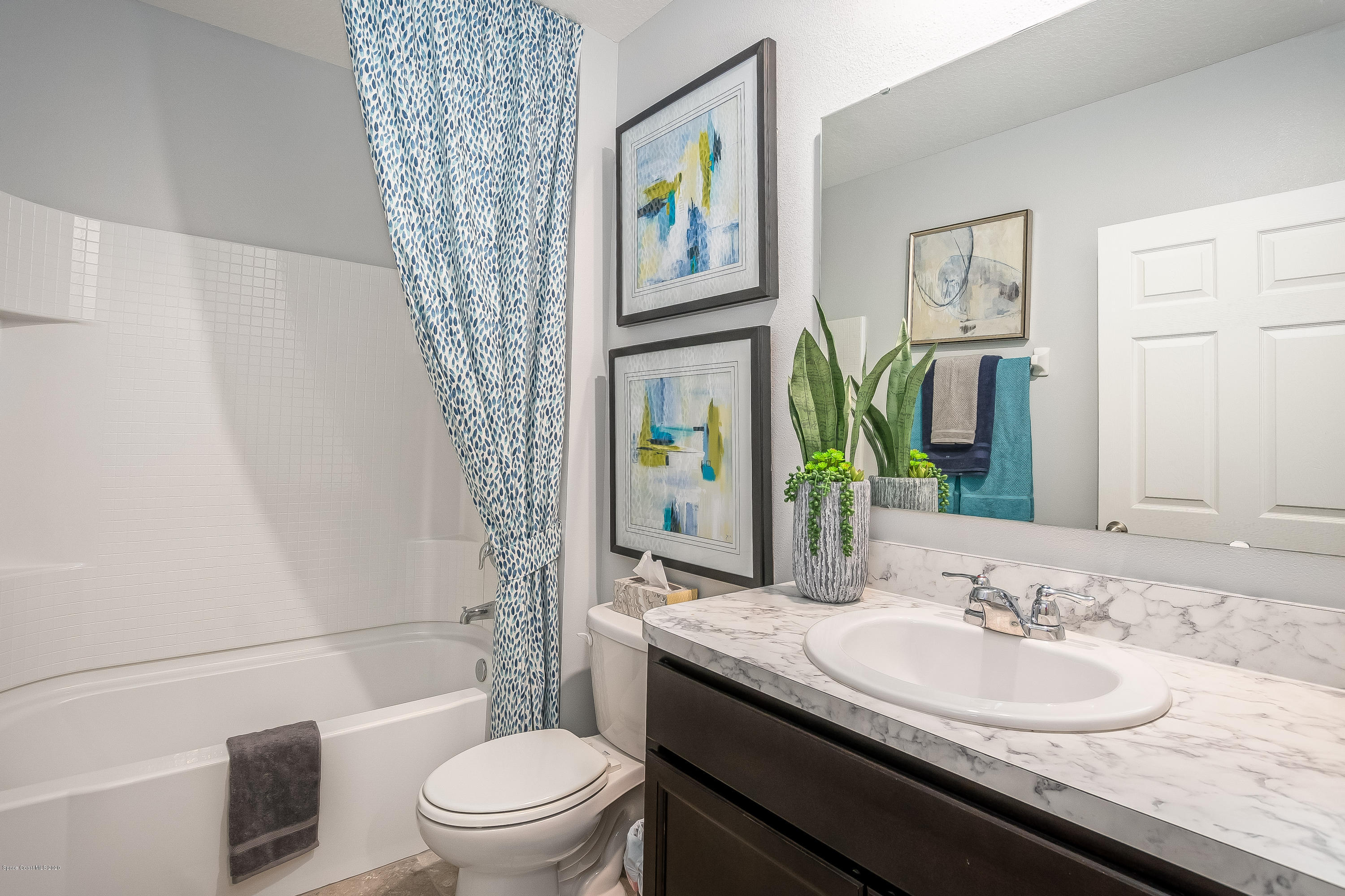 3873 Sandhill Crane Circle Mims, FL 32754 - Photo 18 of 32 a bathroom with a granite countertop sink a toilet a mirror and shower