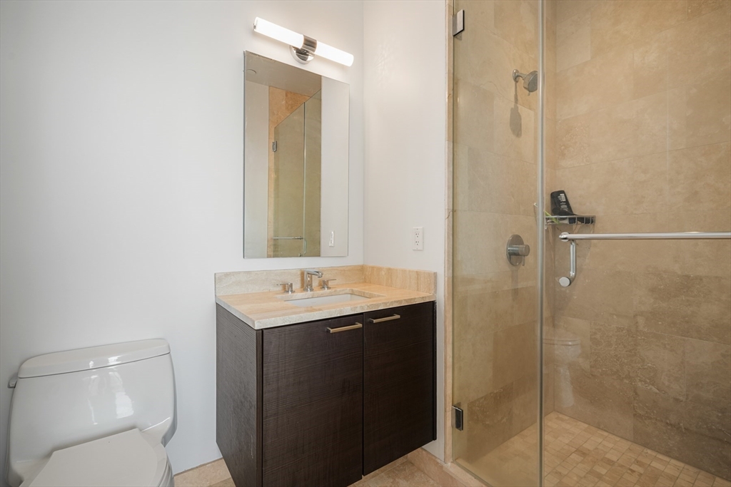 1 Franklin Street, Unit 4802 Boston, MA 02110 - Photo 23 of 42 a bathroom with a granite countertop sink toilet and shower